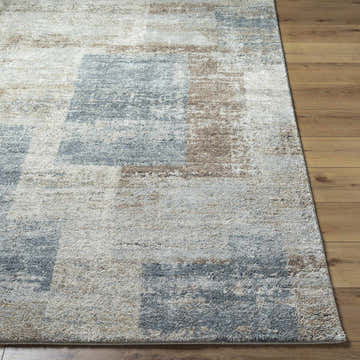 Close-up of the Yasma Thick Luxe Rug. Beige, gray, and tan blocks create a contemporary pattern on a plush, textured rug. Front