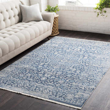 Living room scene with a Yorkana Distressed Blue Rug, beige sofa, dark wood floors, and white brick wall. Roomscene-Rectangle