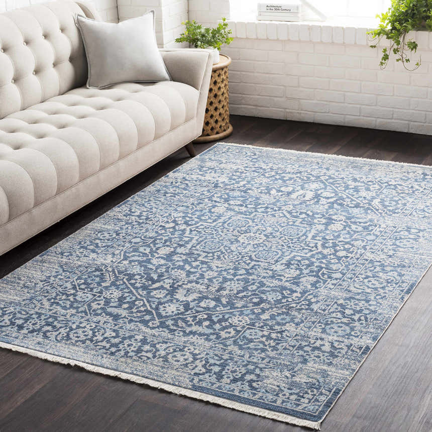 Living room scene with a Yorkana Distressed Blue Rug, beige sofa, dark wood floors, and white brick wall. Roomscene-Rectangle