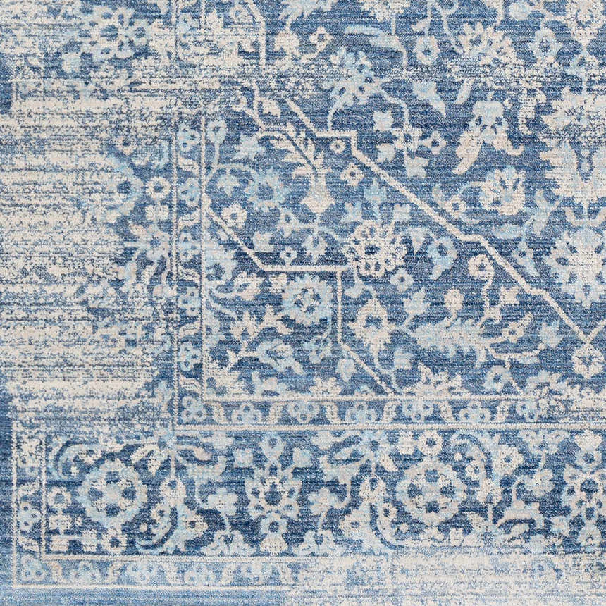 Close-up of the Yorkana Distressed Blue Rug, showcasing its traditional floral pattern and distressed texture in blue and beige. Swatch