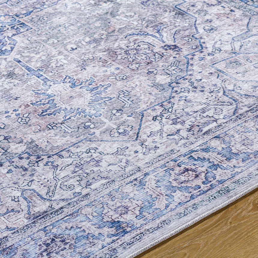 Close-up of the Yoshi Washable Area Rug. Traditional pattern in cream, denim, gray, and rust colors. Machine woven texture. Texture