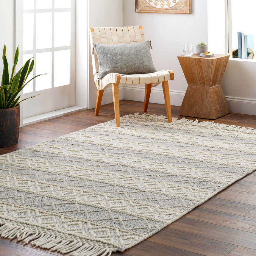 Neutral entryway with Zaza Wool Rug. Bone and gray geometric rug with tassels, woven chair, and wood accents. Roomscene-Rectangle