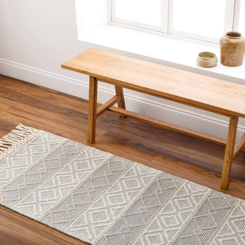 Entryway with wood bench and gray Zaza Wool Rug. Farmhouse style with geometric pattern and tassels. Roomscene-Runner