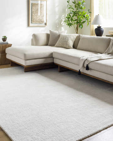 Living room with a light beige sectional sofa and Zareh Off White Solid Area Rug. Roomscene-Rectangle
