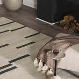 Living room scene with the beige Aibonito hand tufted wool rug, black accents, and a cozy fireplace. Roomscene-Rectangle