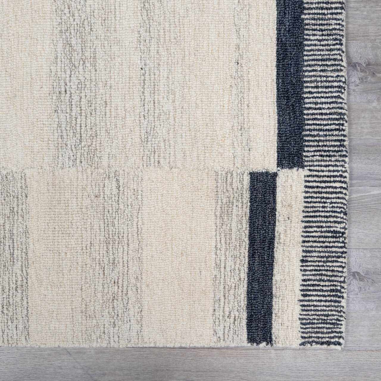 Close-up of the Aibonito hand tufted wool area rug featuring beige, gray, and black stripes. Wool texture visible. Swatch