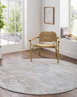 Light-filled living room with a round Ambra Thick Luxe Boutique Rug in cloud gray and beige under a woven chair. Roomscene-Round