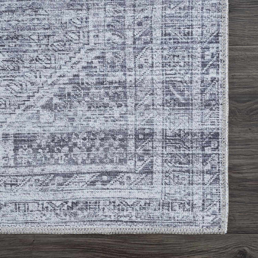 Close-up of the Barny Gray Blue Washable Rug showing its traditional pattern and charcoal and off-white color wash. Swatch