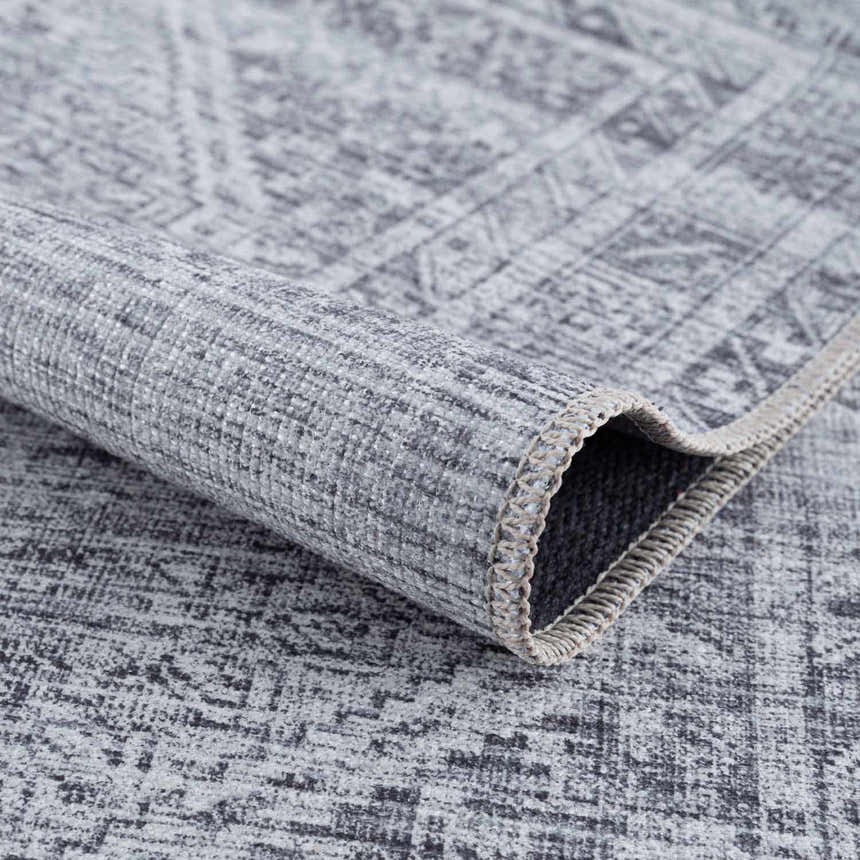Close up of the Barny Gray Blue Washable Rug showing its texture and traditional pattern. Fold