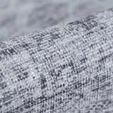 Close-up of the Barny Gray Blue Washable Rug, showing its woven texture and charcoal, gray, and off-white colors. Fold