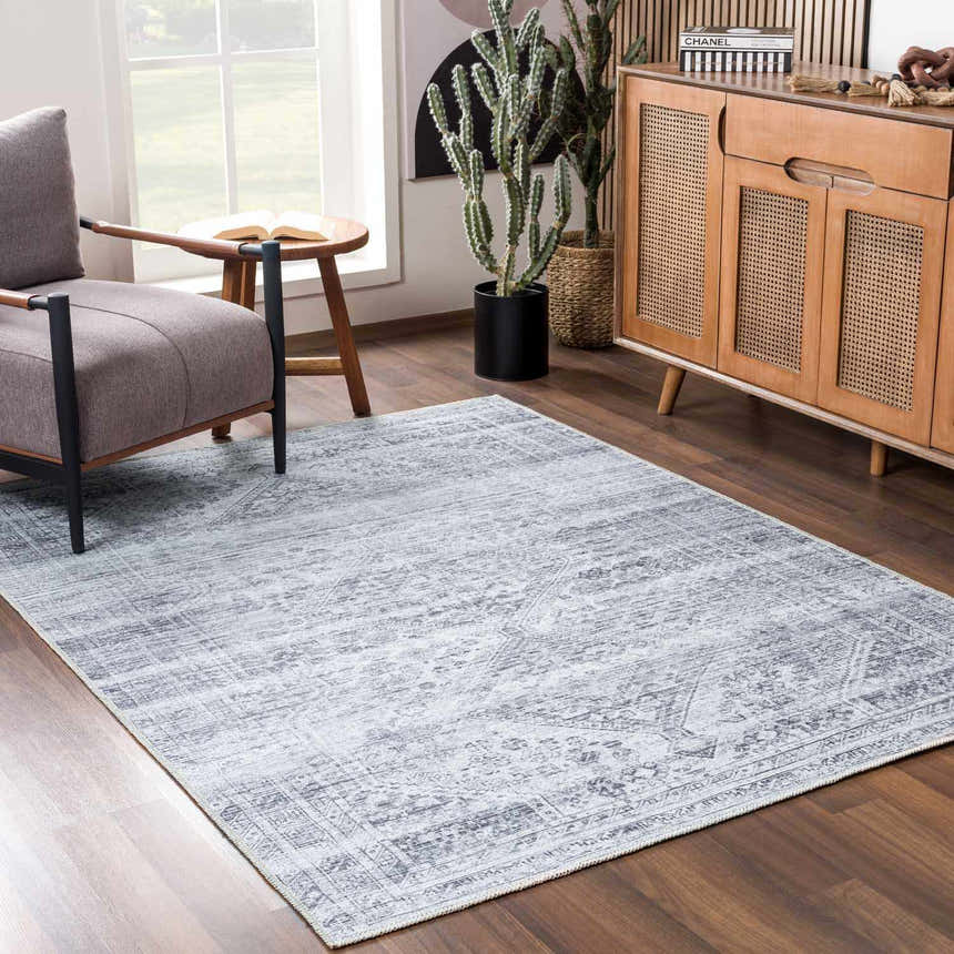 Living room scene with gray armchair and Barny Gray Blue Washable Rug. Wood floors and mid-century modern cabinet. Roomscene-Rectangle