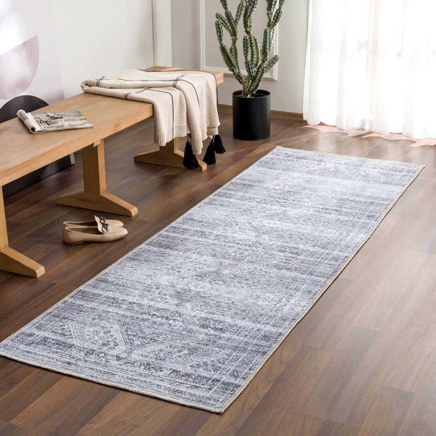 Entryway scene with a Barny Gray Blue Washable Rug, wooden bench, blanket, and cactus on wood floors. Roomscene-Runner