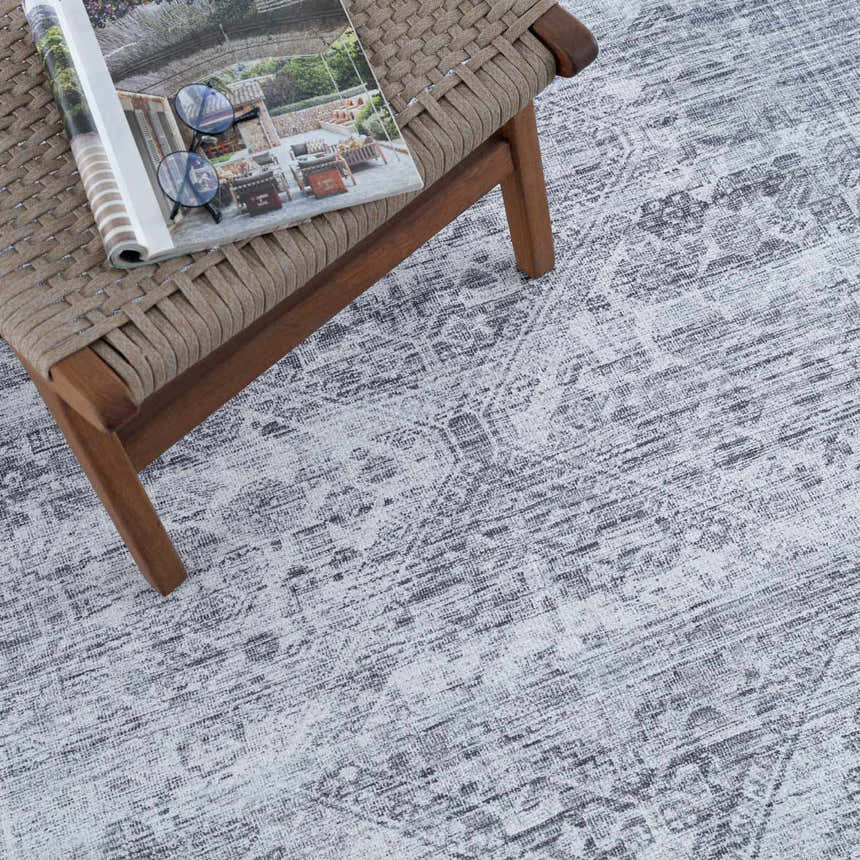 Close up of the Barny Gray Blue Washable Rug showing its charcoal and off white traditional design and texture. Styleshot