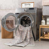 Laundry room scene with a Barny Tan Washable Area Rug partially inside a front-load washing machine. Washing-Machine