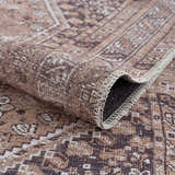 Close-up of the Barny Brown Flat Pile Washable Rug, showcasing its traditional brown, cream, and gray pattern and chenille texture. Fold