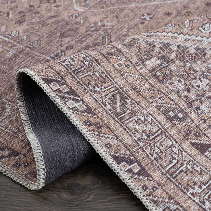 Close-up of the Barny Brown Flat Pile Washable Rug showing its traditional light brown, cream, and gray pattern and flat weave. Fold