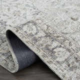 Close-up of the Haile Boutique Washable Rug showing its traditional gray pattern, texture, and durable backing. Fold