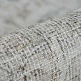 Close-up of the woven texture of the Haile Boutique Washable Rug in gray, nutmeg, and smoke. Fold
