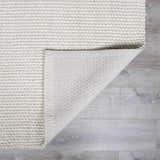 Close-up of the textured, hand-woven Lucerne Plain Cream Wool Rug LNE-1000 showing the backing. Fold