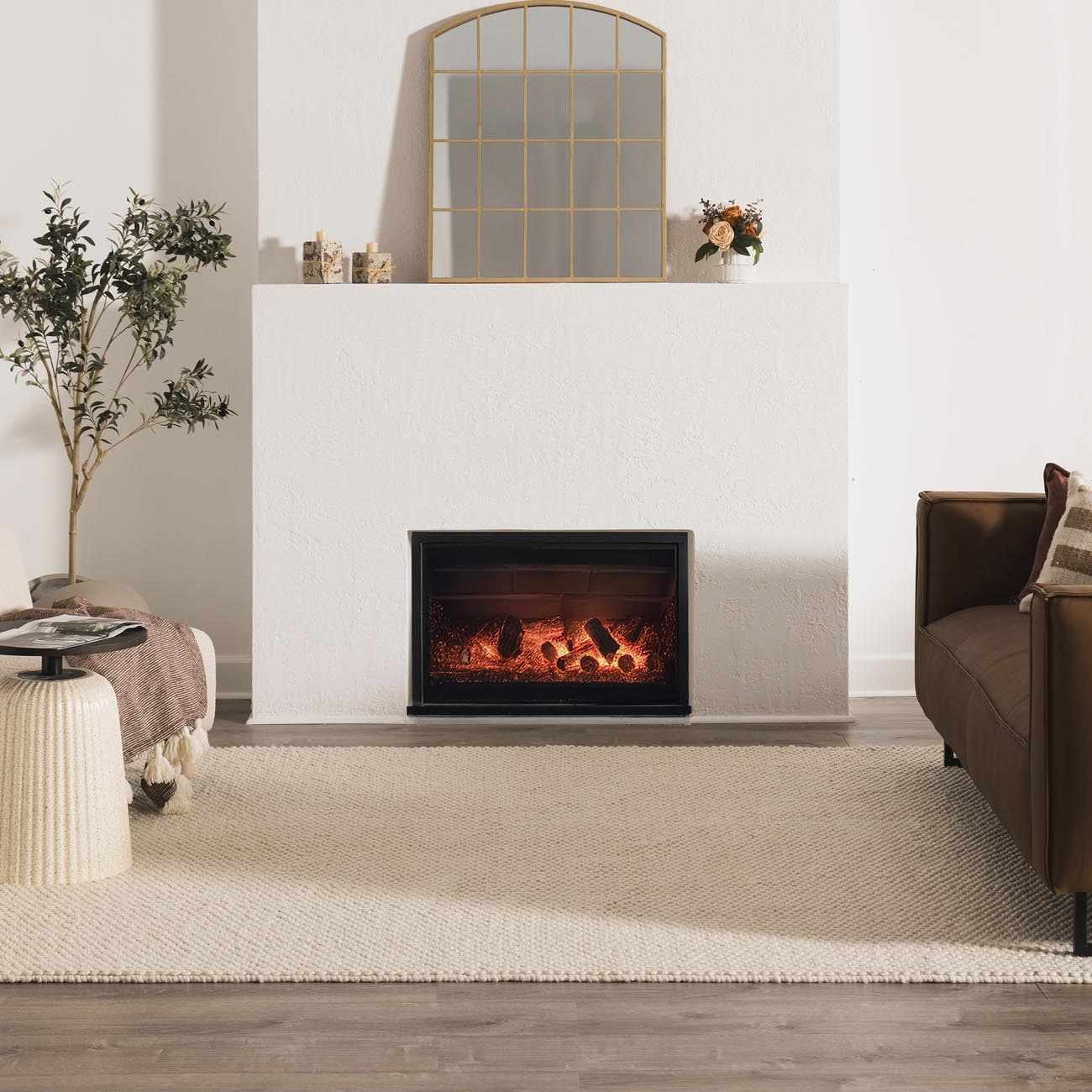 Living room scene with a cream Lucerne Plain Wool Rug, fireplace, brown sofa, and neutral decor. Roomscene-Rectangle