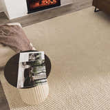 Living room scene with a Lucerne Plain Cream Wool Rug, fireplace, and modern decor. Styleshot
