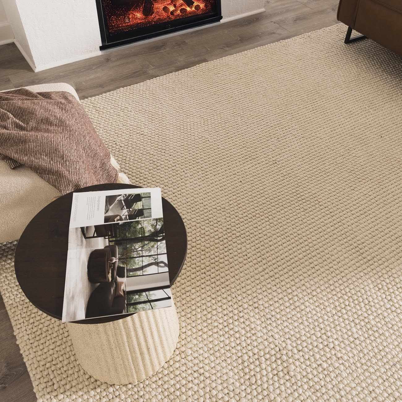 Living room scene with a Lucerne Plain Cream Wool Rug, fireplace, and modern decor. Styleshot