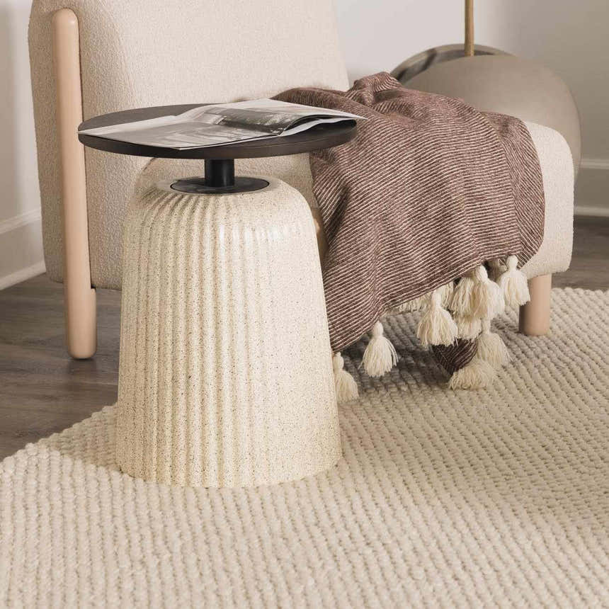 Close-up of the cream-colored, hand-woven texture of the Lucerne Plain Cream Wool Rug. Styleshot