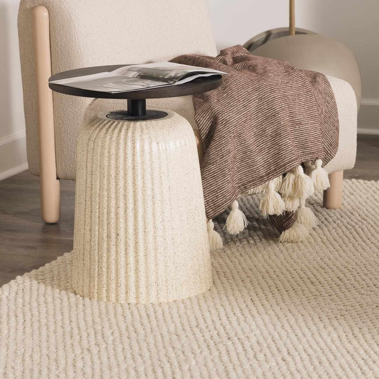 Close-up of the cream-colored, hand-woven texture of the Lucerne Plain Cream Wool Rug. Styleshot