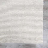 Close-up of the hand woven Lucerne Plain Cream Wool Rug showing texture and color. Swatch