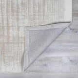 Close-up of the Auchter Soli Taupe Premium Sheer Carpet showing its textured, medium gray striped design and backing. Fold