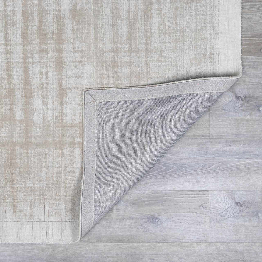 Close-up of the Auchter Soli Taupe Premium Sheer Carpet showing its textured, medium gray striped design and backing. Fold
