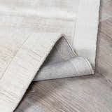 Close-up of the Auchter Soli Taupe rug showing its premium sheer texture, hand-loomed construction, and medium gray color. Fold