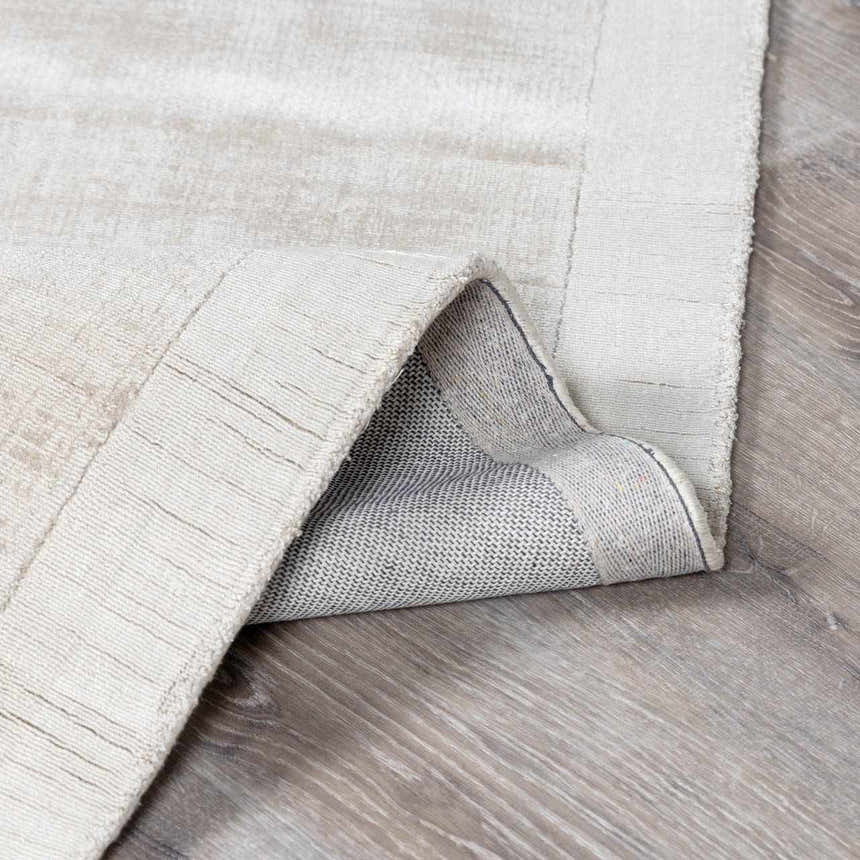 Close-up of the Auchter Soli Taupe rug showing its premium sheer texture, hand-loomed construction, and medium gray color. Fold
