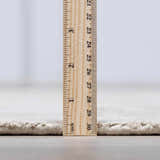 Close-up of the Auchter Soli Taupe rug showing its pile height with a ruler. Premium sheer carpet texture. Pile