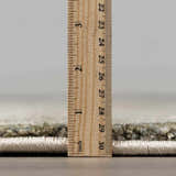 Close-up of the Zazie Thick Luxe Rug showing its pile height with a ruler. Colors: Beige, Gray, Olive. Pile
