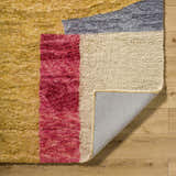Close up of the hand tufted Budrys Wool Area Rug showing brick red, camel, and pearl colors. Fold