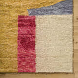 Close-up of the hand-tufted Budrys Wool Area Rug. Features brick red, camel, pearl, and gray colors in a contemporary design. Corner