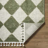 Close-up of the Aitana Area Rug showing cream and olive diamond pattern, texture, and tassels. Fold