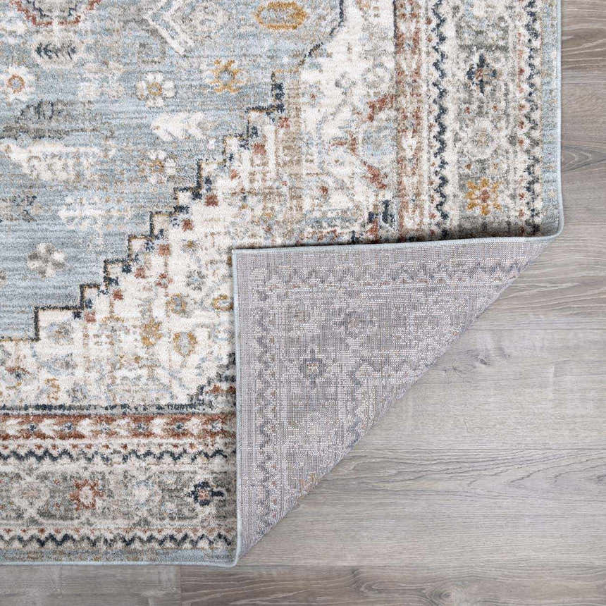 Close-up of the Kouta Gray Blue Area Rug showing its traditional pattern, soft texture, and durable machine-woven construction. Fold