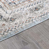 Close-up of the Kouta Gray Blue Area Rug showing its farmhouse-style pattern, soft texture, and colors like beige and ice blue. Pile
