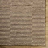 Close-up of the hand-tufted Idaho Broken-Striped Brown Area Rug. Beige, sandstone, and taupe wool stripes create a contemporary design. Corner