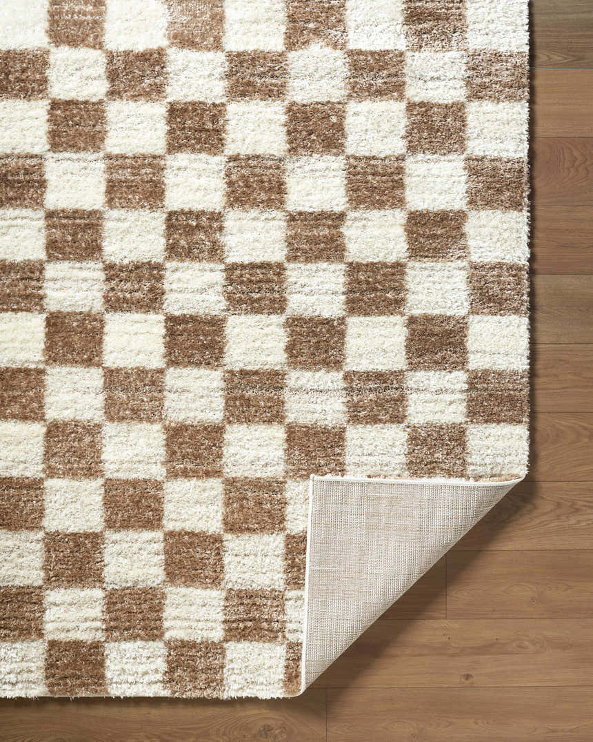 Close-up of Belita Cream Luxe Shag Area Rug. Cream and tan checkerboard pattern, plush texture, machine woven. Fold