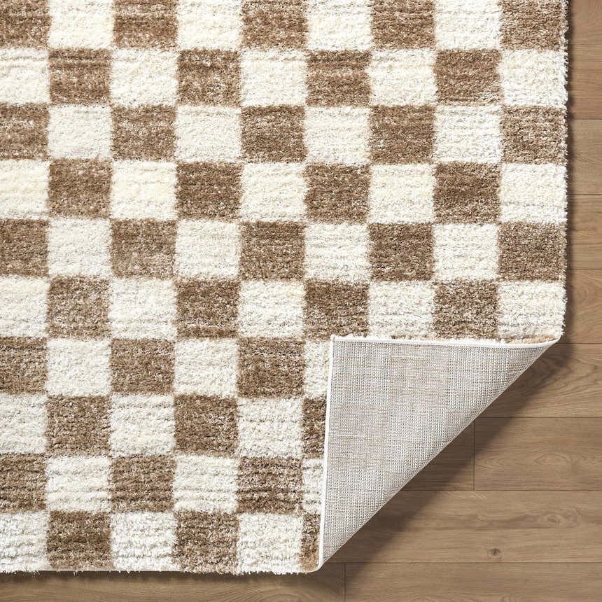 Close-up of the Belita Cream Luxe Shag Area Rug showing cream and tan checkerboard pattern and soft, shag texture. Fold