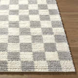 Close-up of Belita Tan Luxe Shag Area Rug with cream and light gray checkerboard pattern and soft, shag texture. Front