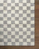 Close-up of the Belita Tan Luxe Shag Area Rug featuring a cream and light gray checkerboard pattern and a shag texture. Corner