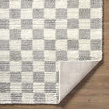 Close-up of the Belita Tan Luxe Shag Area Rug, cream and light gray checkerboard pattern, soft texture. Fold