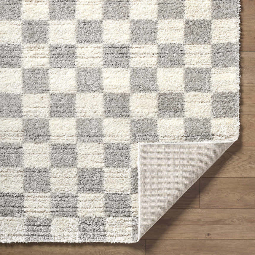Close-up of the Belita Tan Luxe Shag Area Rug, cream and light gray checkerboard pattern, soft texture. Fold