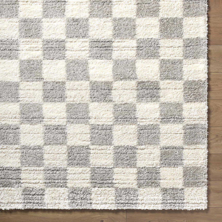 Close up of Belita Tan Luxe Shag Area Rug; cream and light gray checkerboard pattern, soft shag texture. Corner
