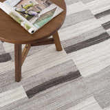 Close-up of Bojana Broken-Striped Area Rug showing black, cream, and gray geometric pattern and textured weave. Styleshot