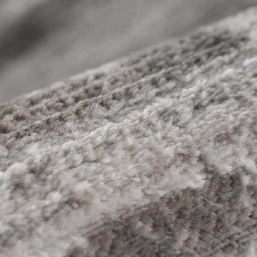 Close-up of the soft, textured pile of the Bojana Broken-Striped Area Rug in cream, off-white, black, and vizon. Texture
